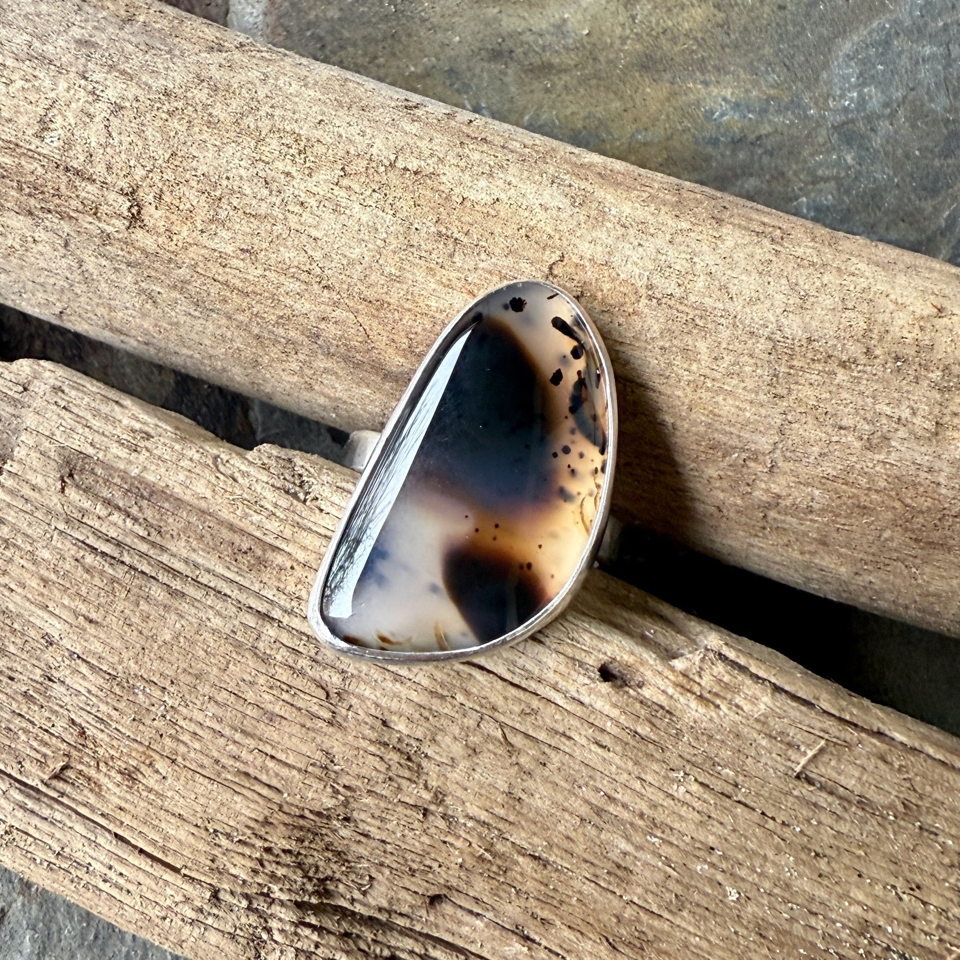 large montana agate ring displayed on driftwood