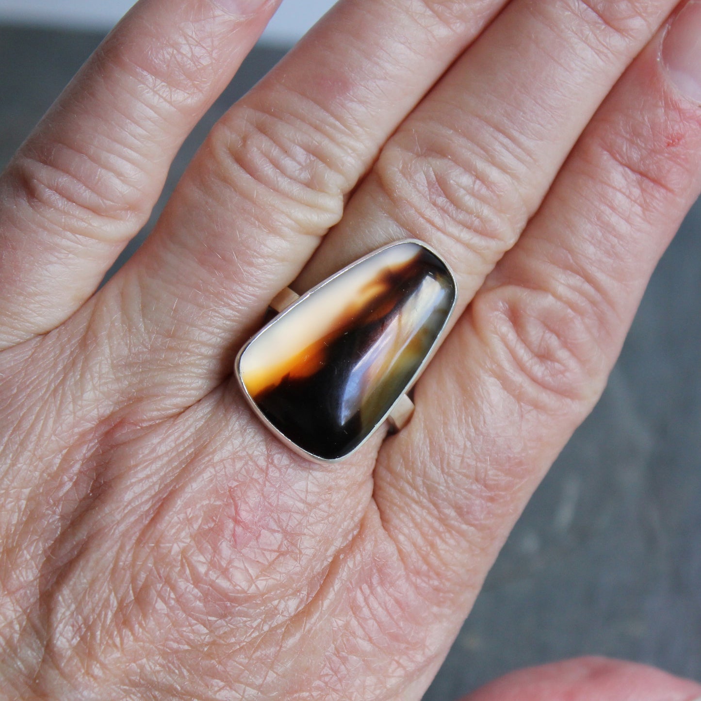 hand wearing a large montana agate statement ring
