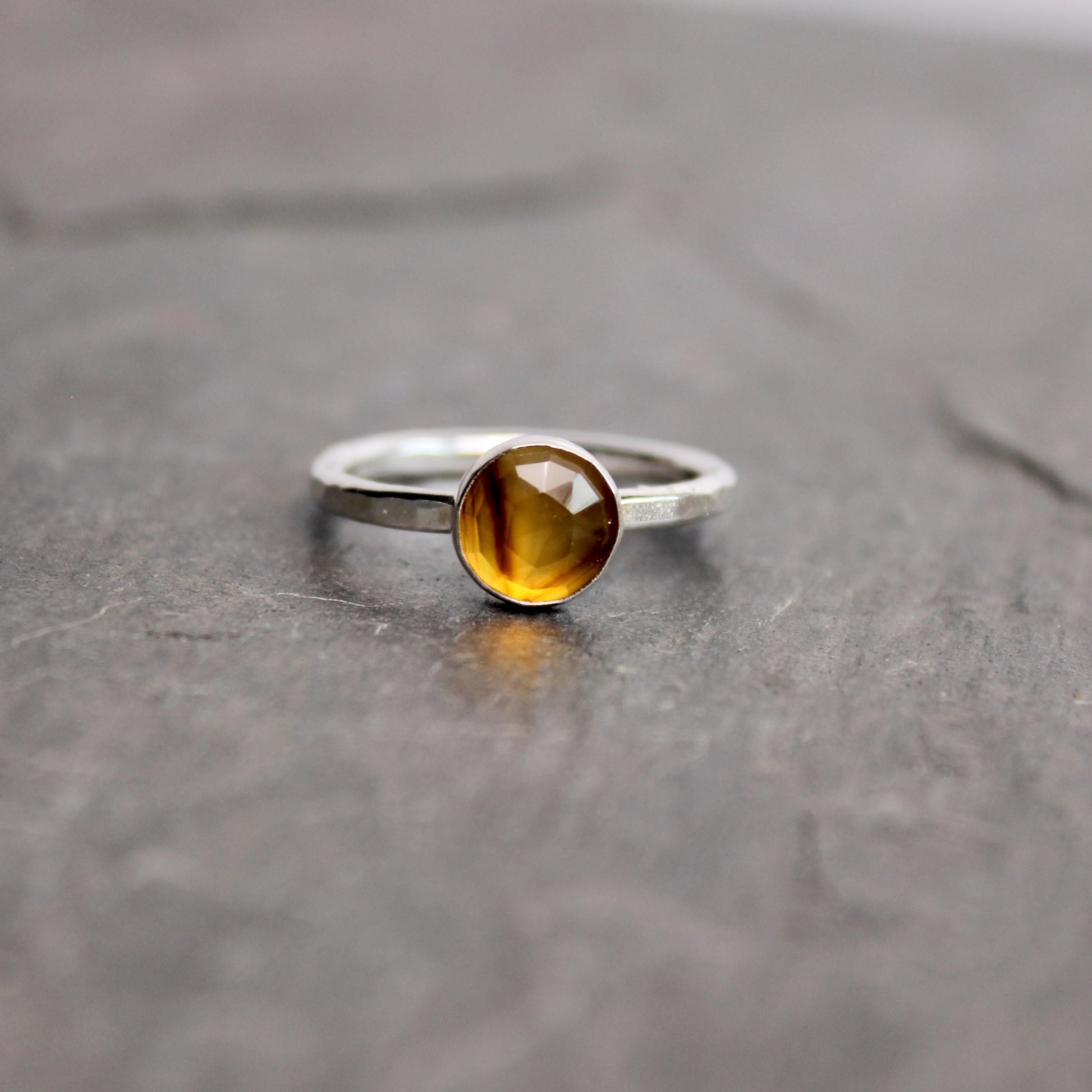 Silver ring with a rose cut montana agate on a gray surface
