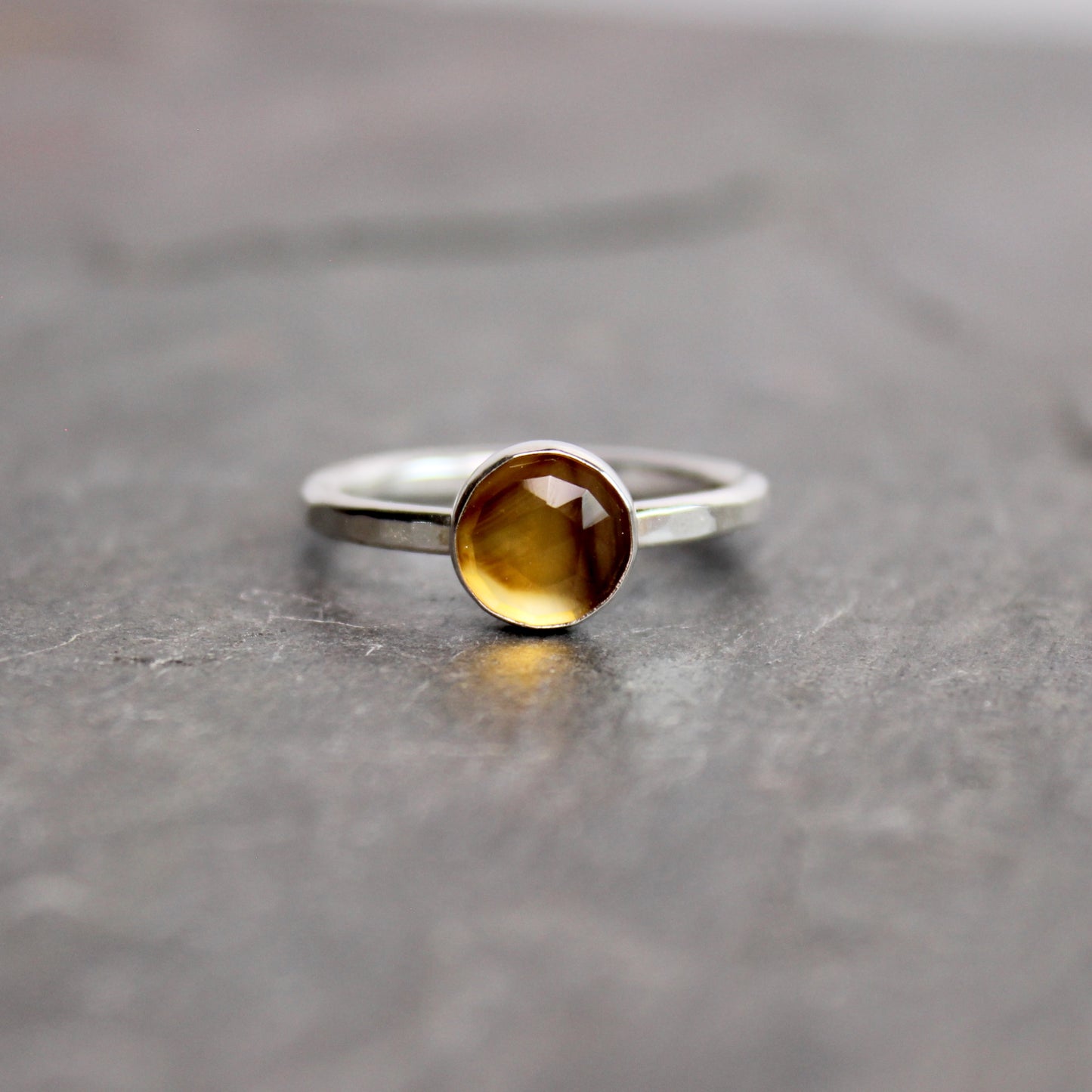 Silver ring with a rose cut montana agate on a gray surface