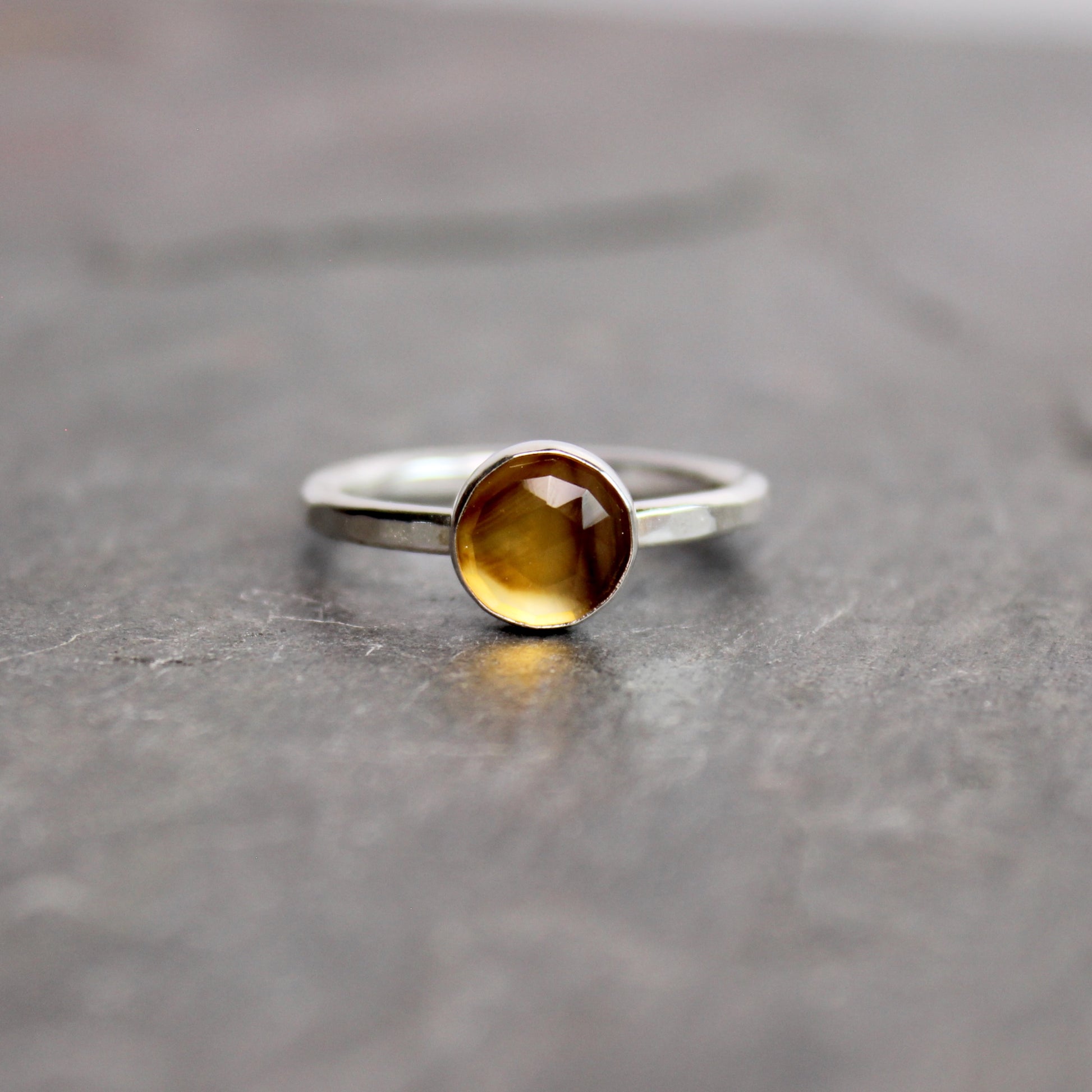 Silver ring with a rose cut montana agate on a gray surface