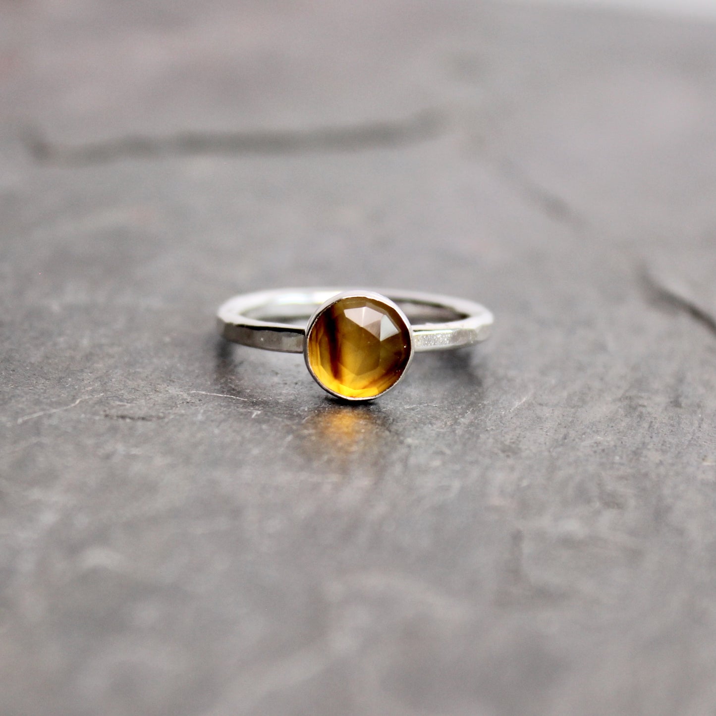 Silver ring with a rose cut montana agate on a gray surface