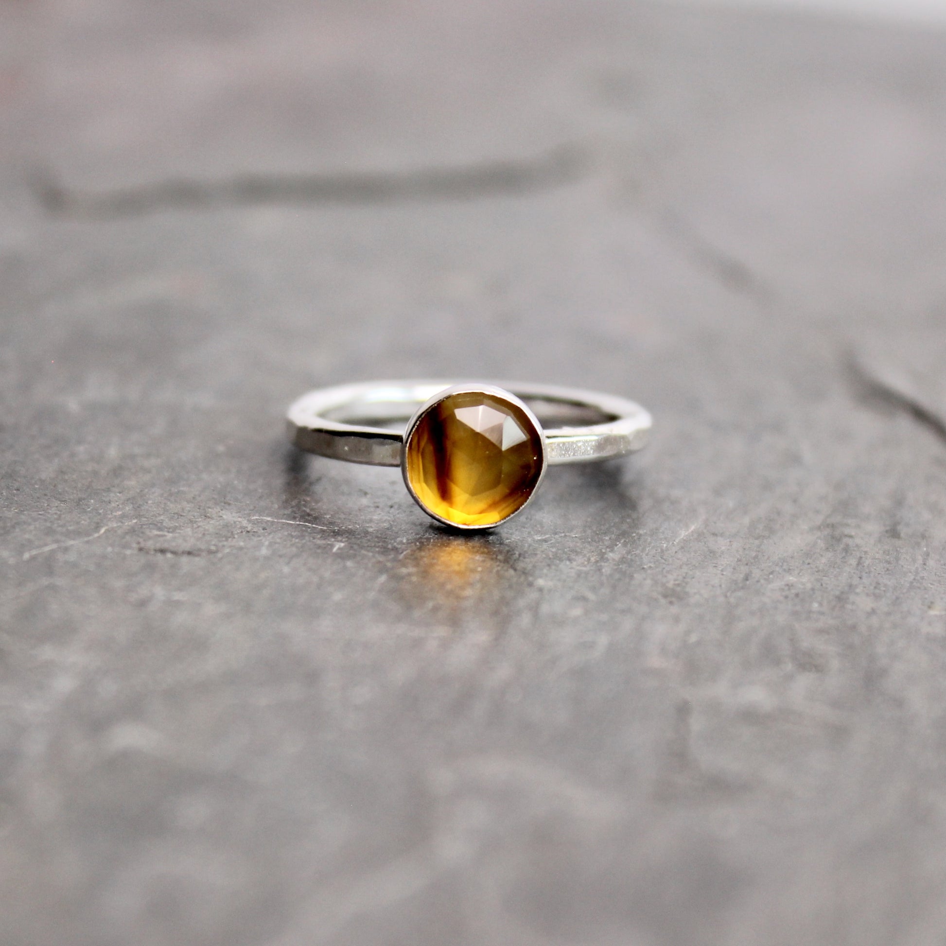 Silver ring with a rose cut montana agate on a gray surface