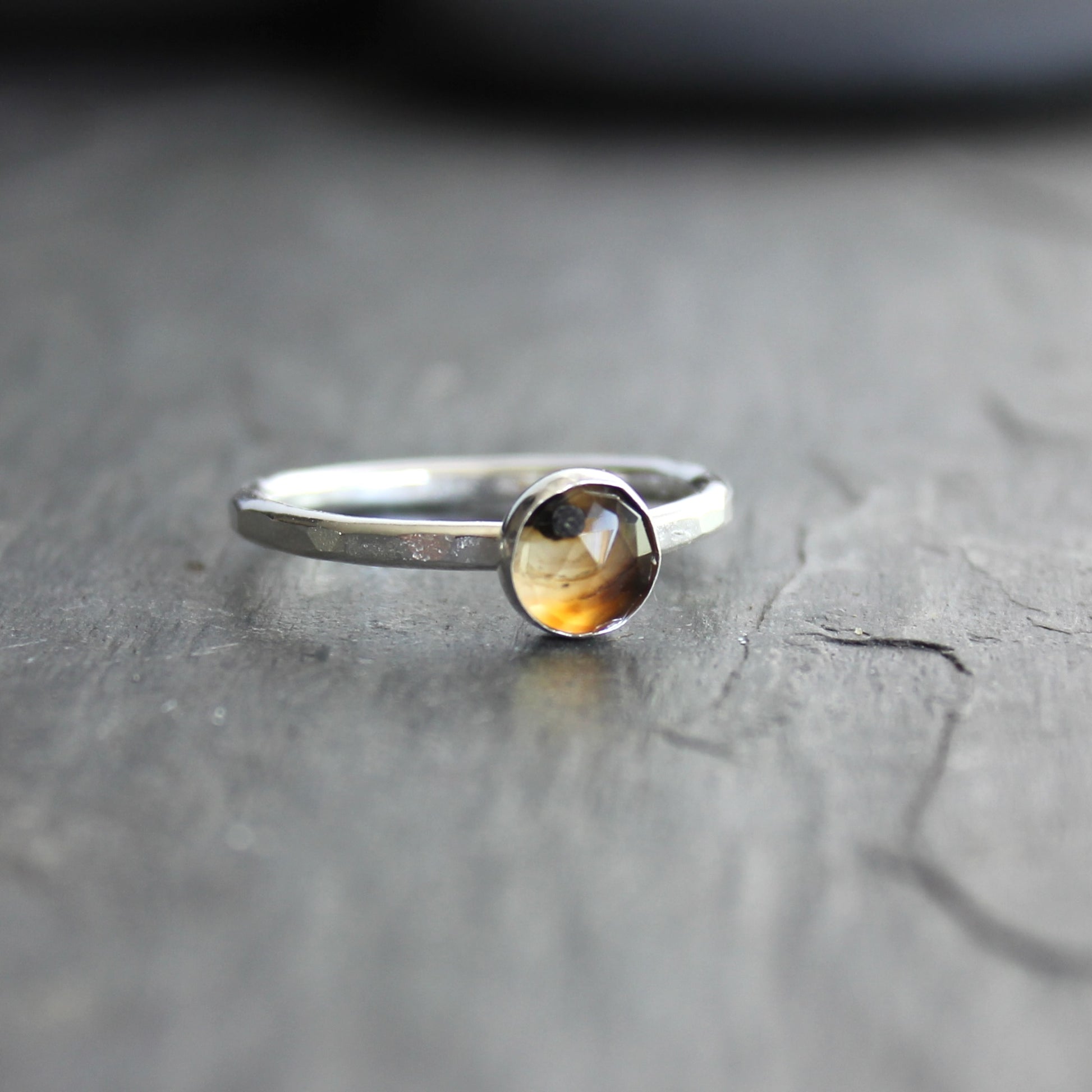 Silver ring with a rose cut montana agate on a gray surface