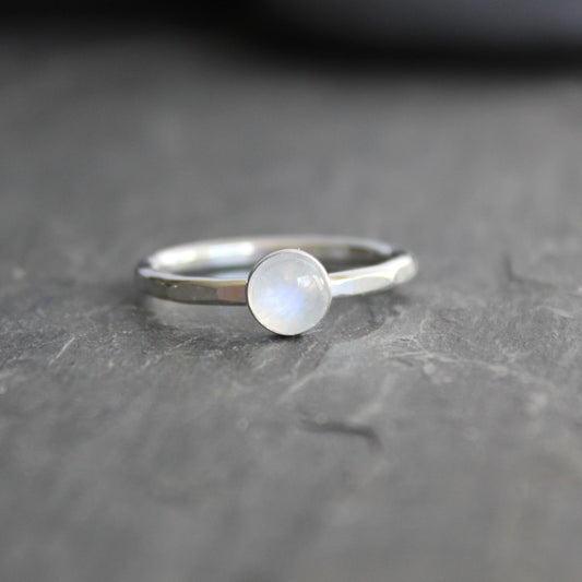 Silver ring with a moonstone on a dark gray surface