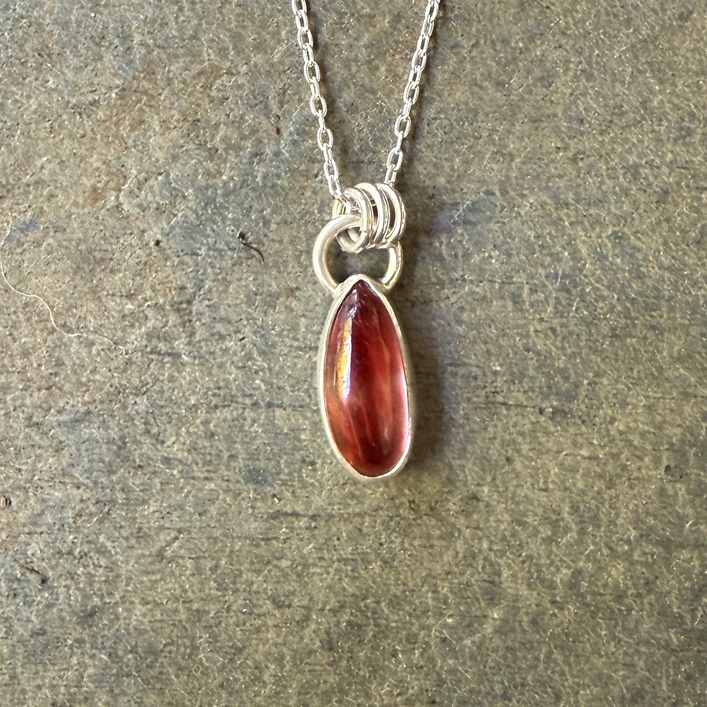 Necklace with an oregon sunstone pendant on a stone surface
