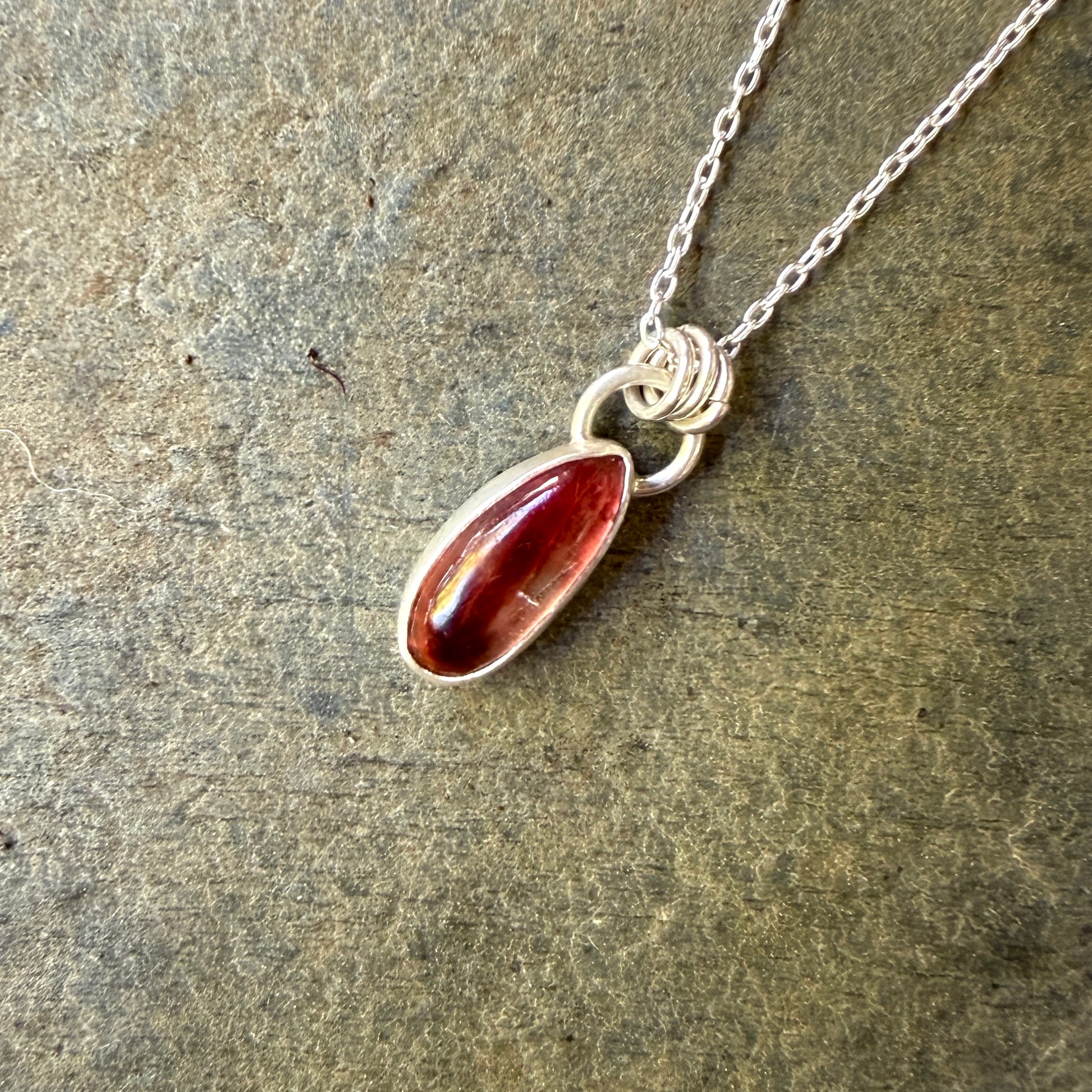 Necklace with an oregon sunstone pendant on a stone surface