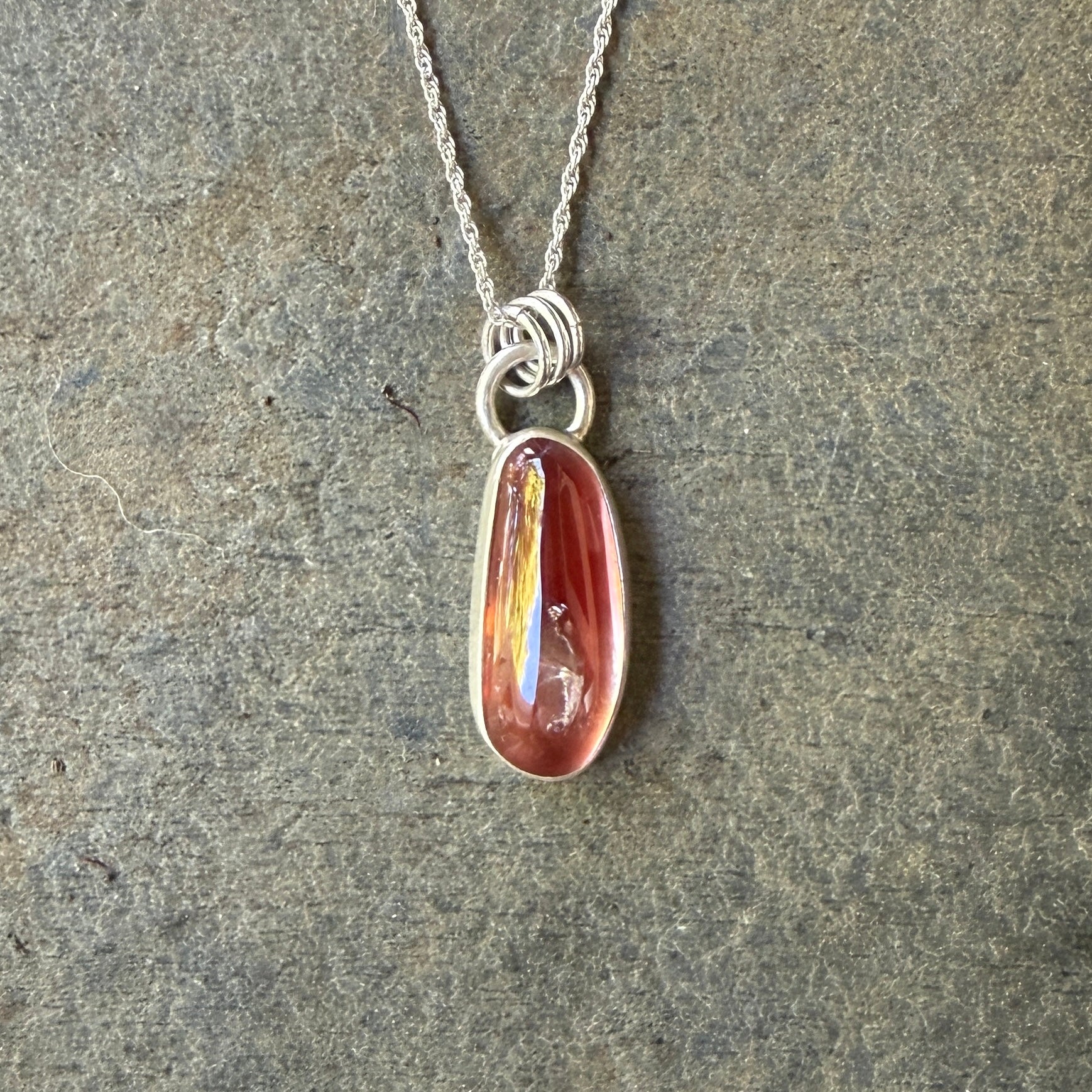 Necklace with an oregon sunstone pendant on a stone surface