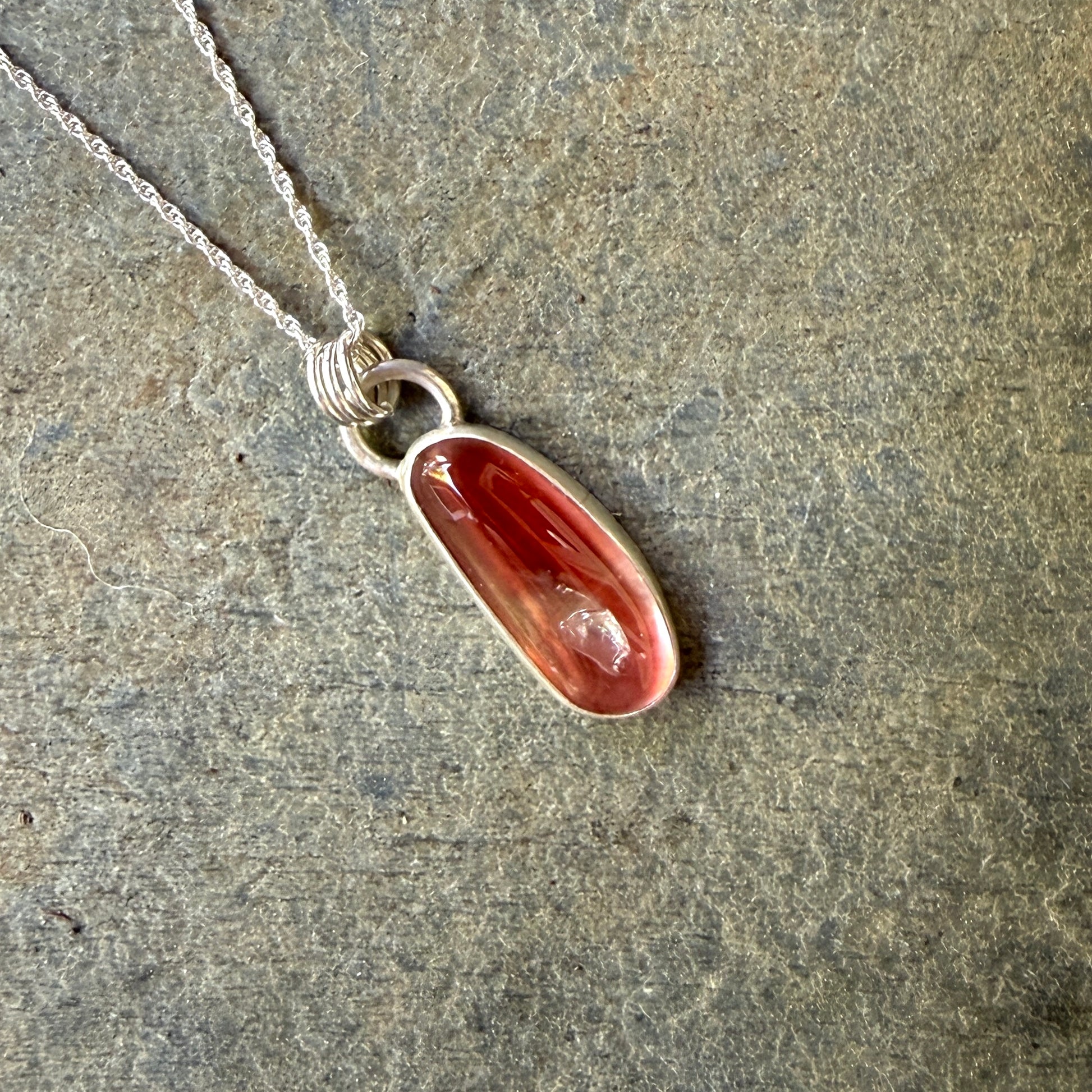 Necklace with an oregon sunstone pendant on a stone surface