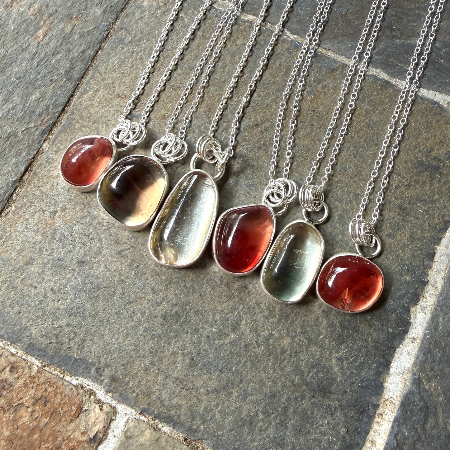 set of six oregon sunstone pendants on a stone surface