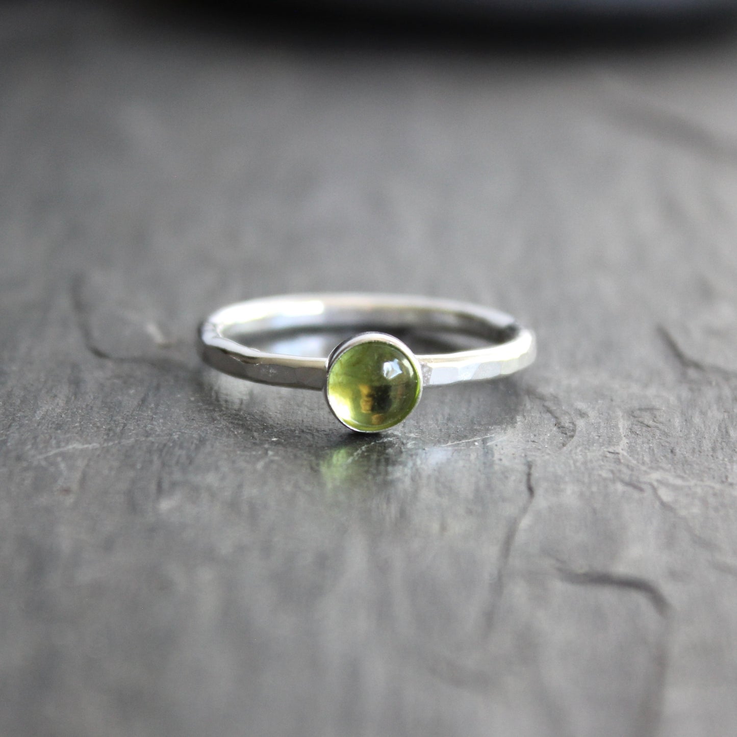 a sterling silver ring with a small green peridot gemstone