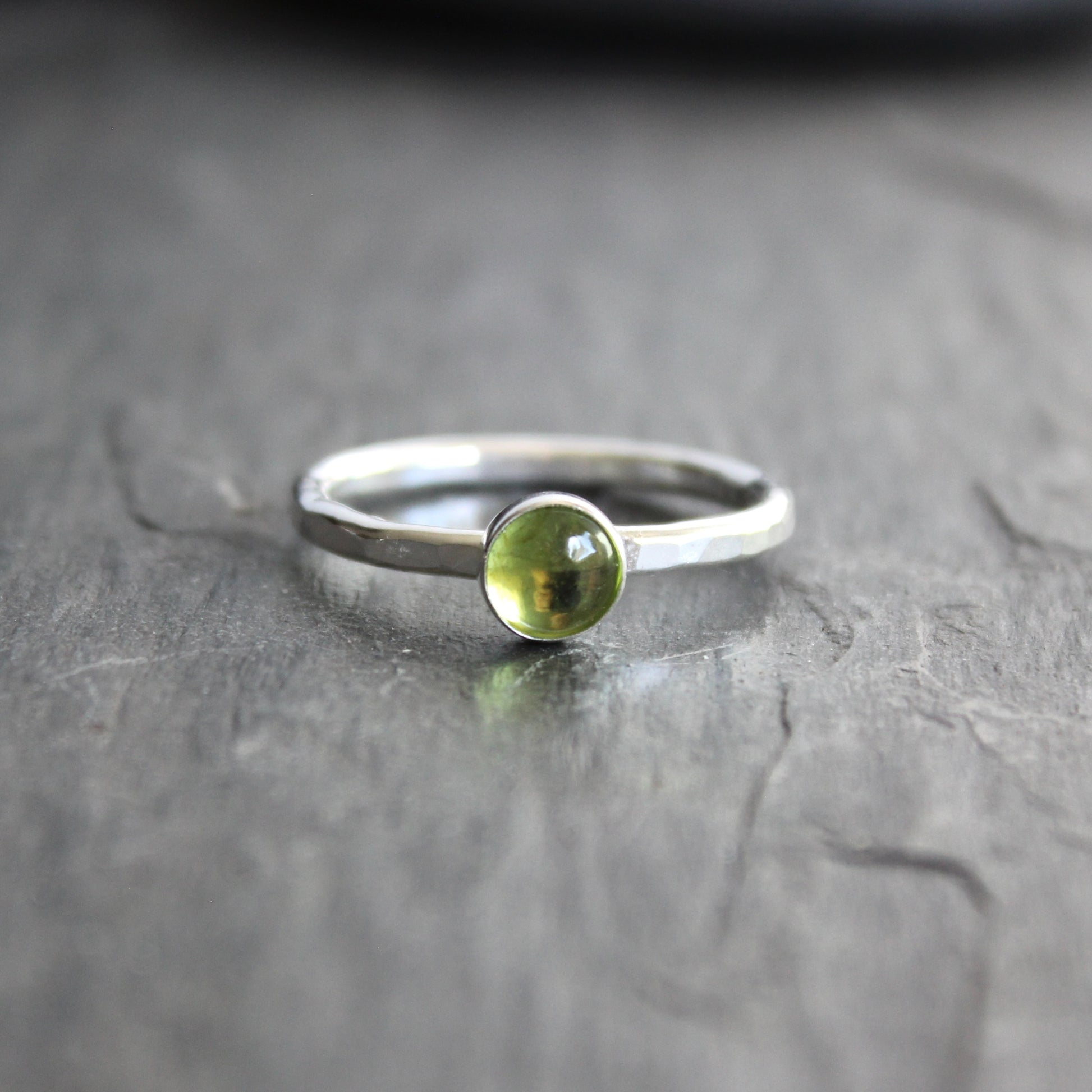 a sterling silver ring with a small green peridot gemstone
