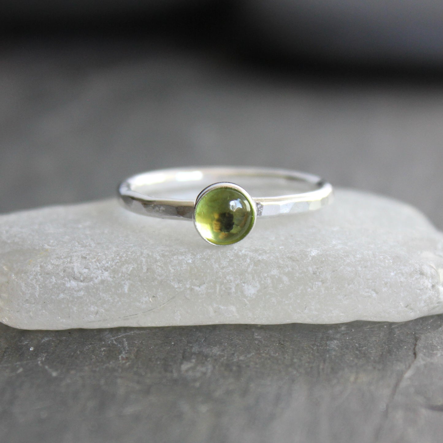 a sterling silver ring with a small green peridot gemstone