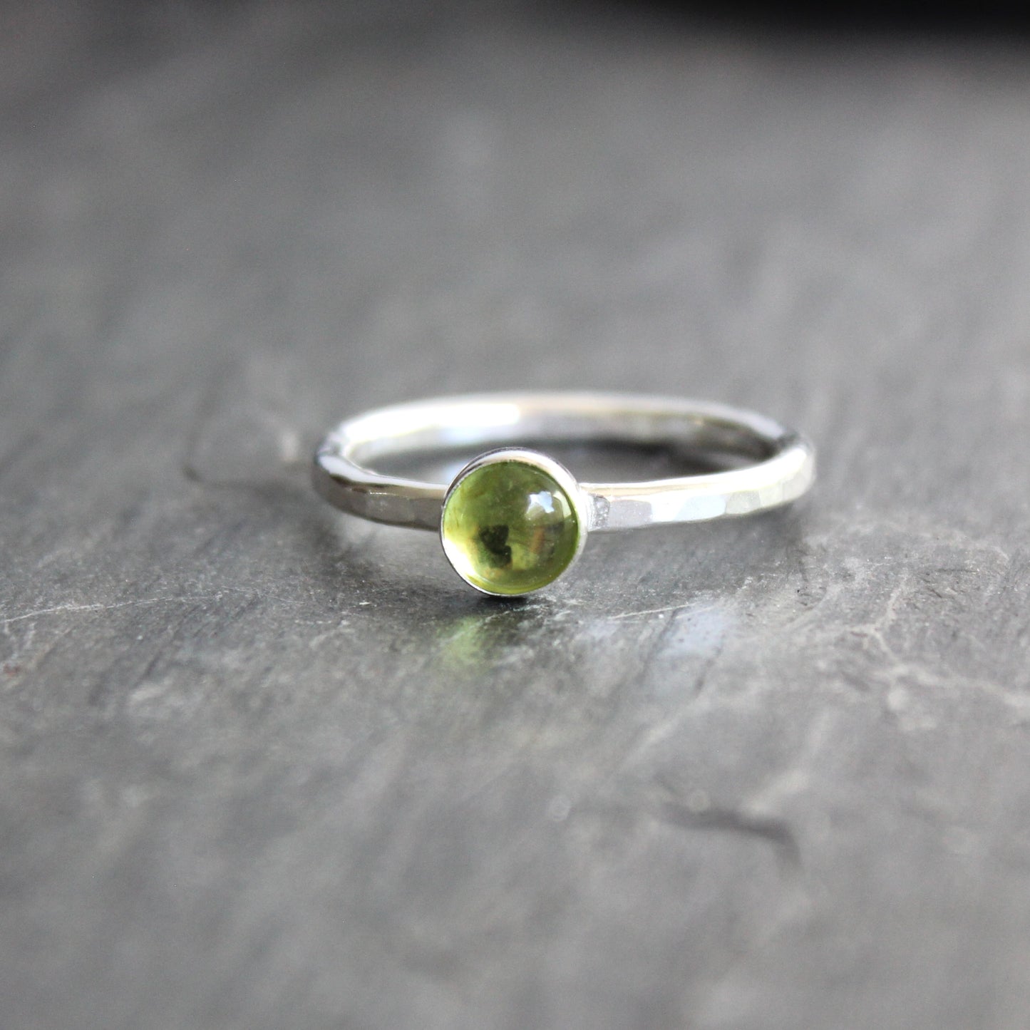 a sterling silver ring with a small green peridot gemstone