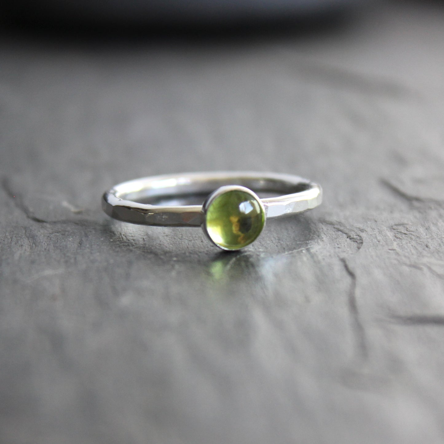 a sterling silver ring with a small green peridot gemstone