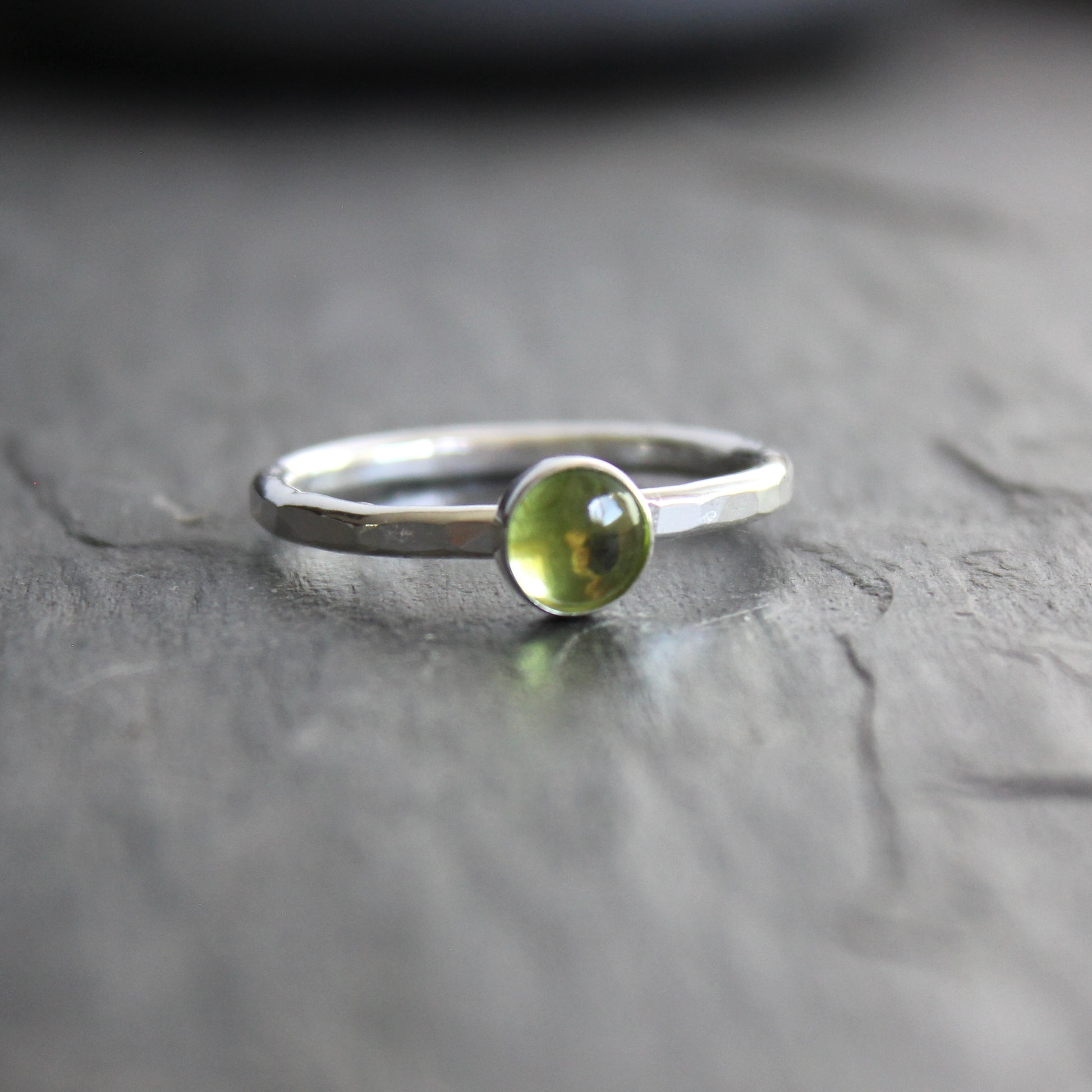a sterling silver ring with a small green peridot gemstone