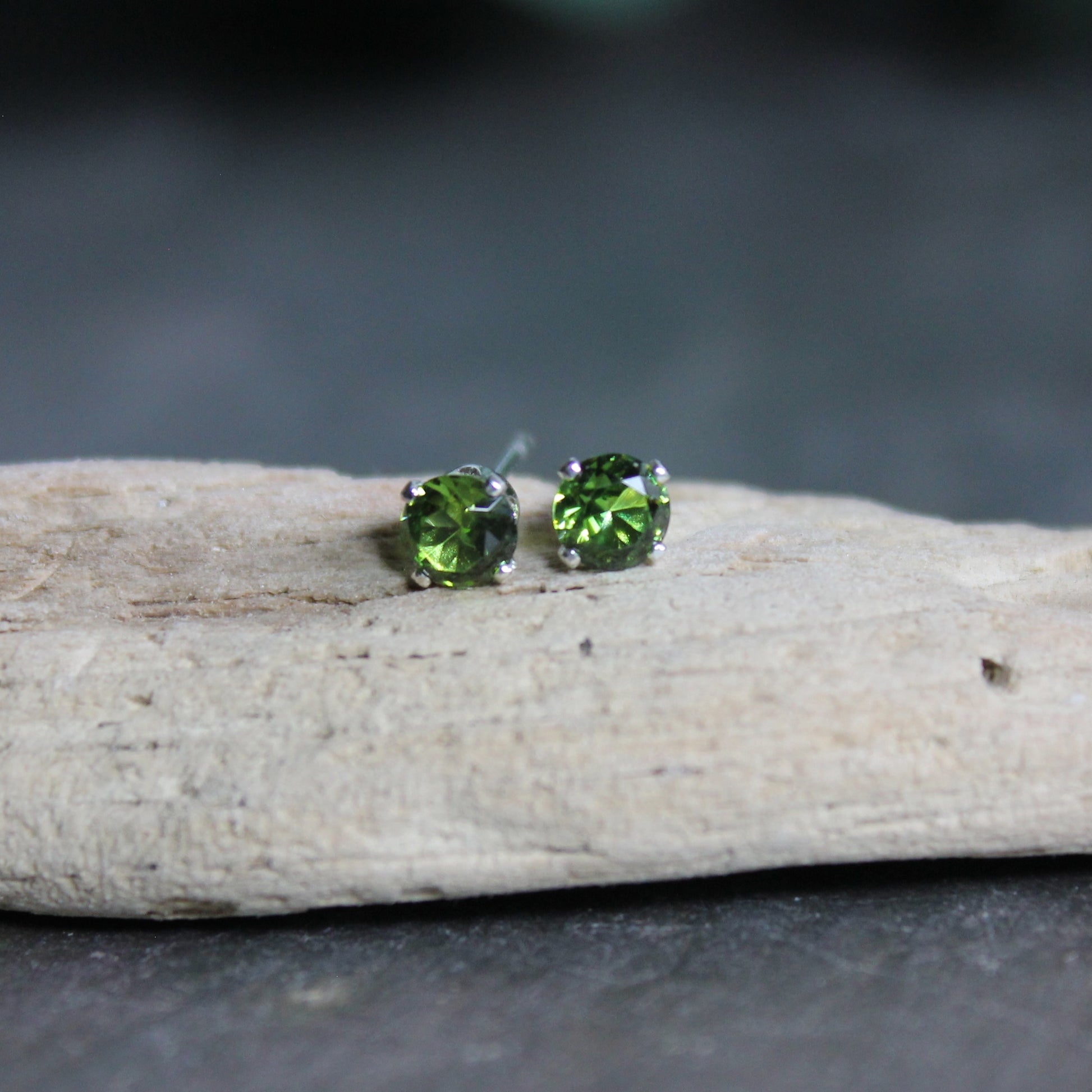 These stud earrings have 4mm round faceted lab created ruby gemstones set in sterling silver 4-prong stud earring settings with earring backs.