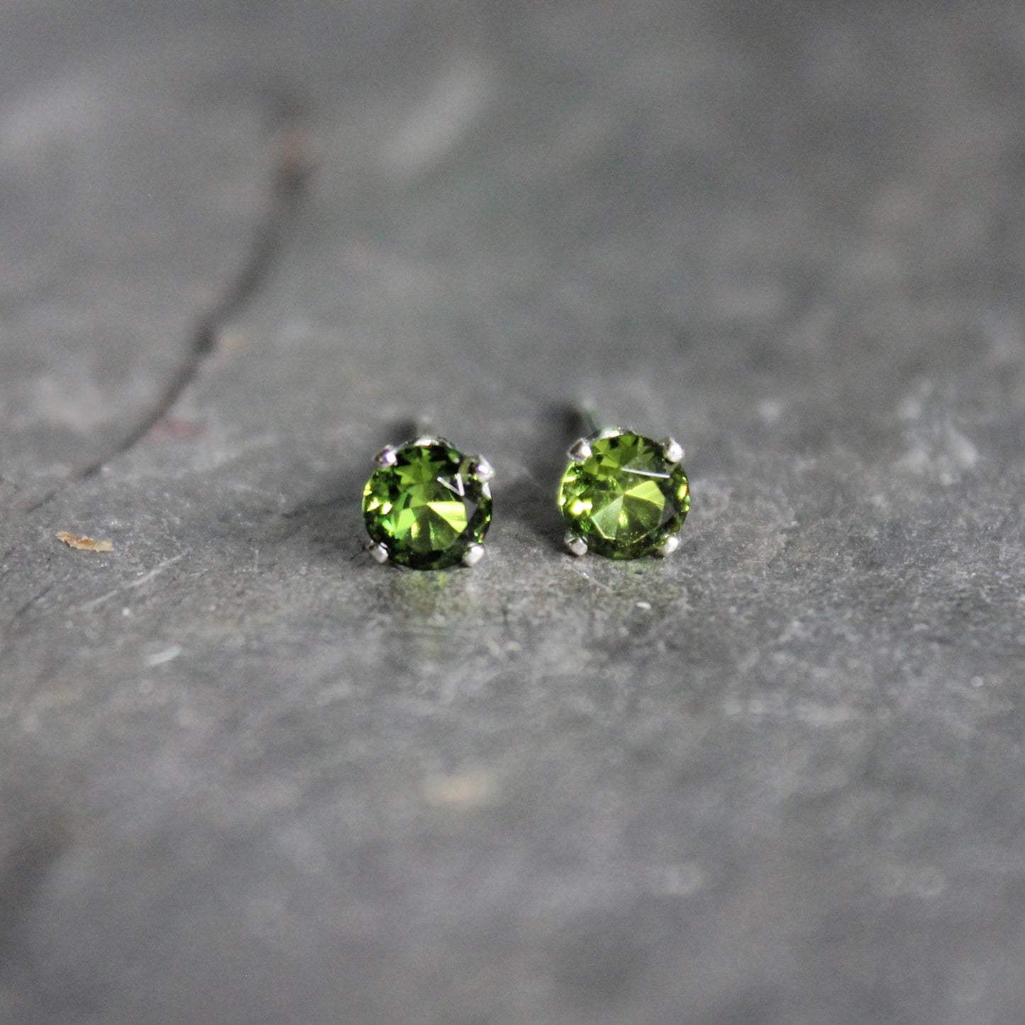 These stud earrings have 4mm round faceted lab created ruby gemstones set in sterling silver 4-prong stud earring settings with earring backs.