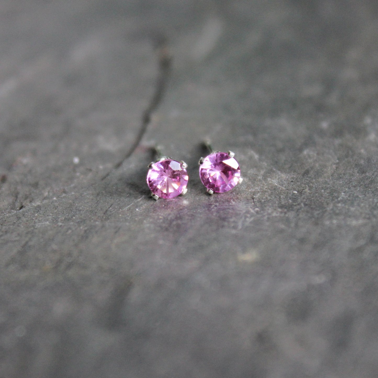 4mm lab created pink tourmaline gemstones set in 4-prong sterling silver stud settings with earring backs. 