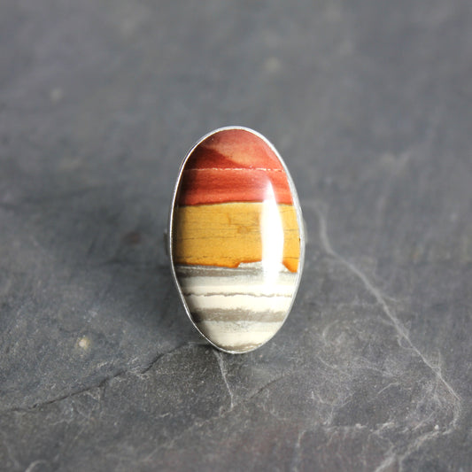 Ring with a multicolored stone on a dark gray background
