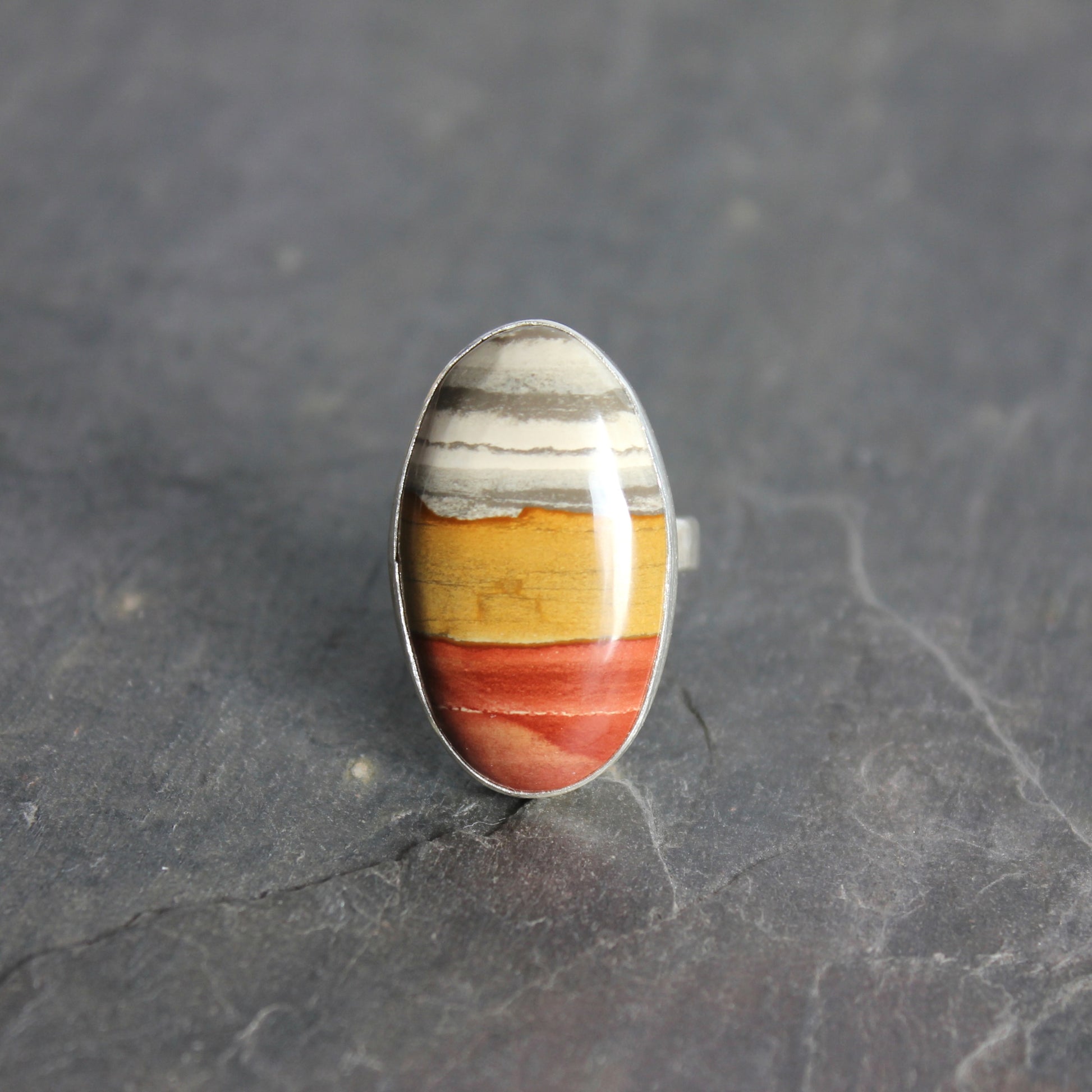Ring with multicolored stone on a dark gray surface