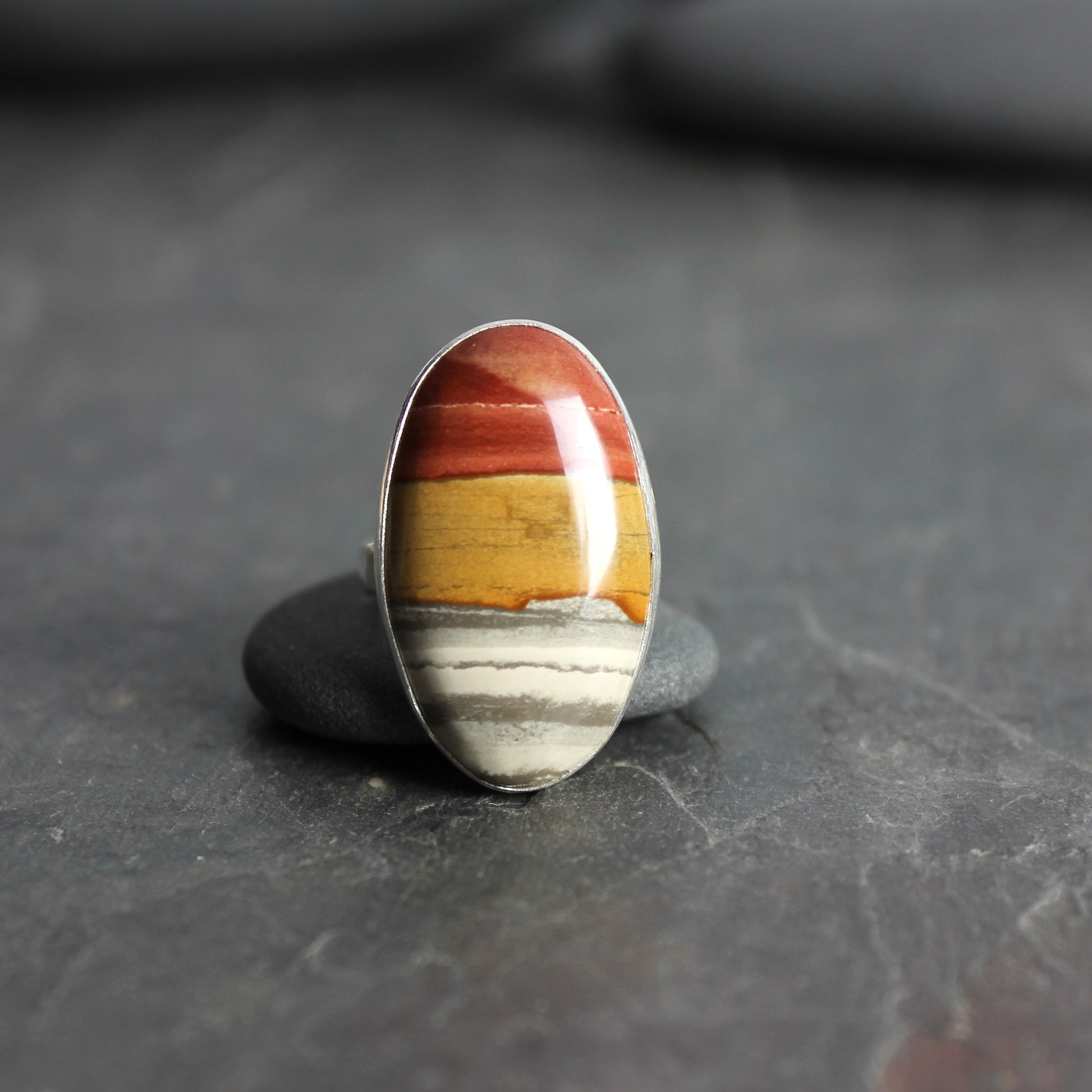 Ring with a multicolored stone on a dark surface