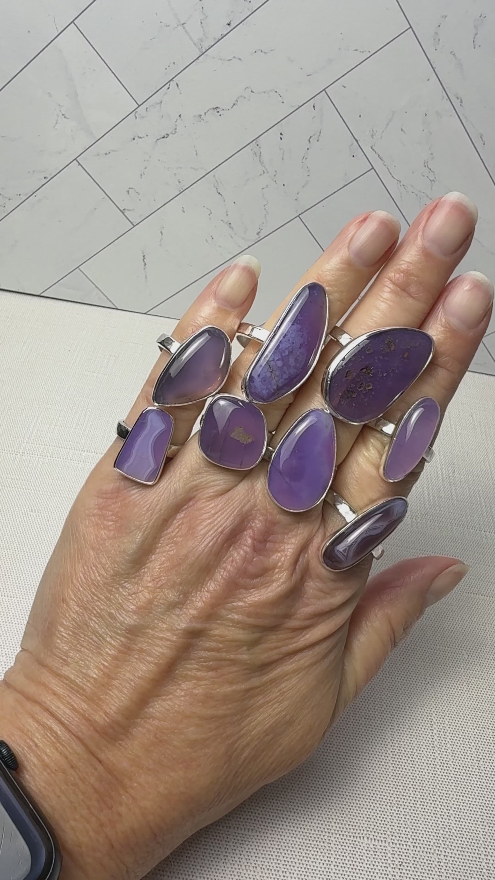 video of a hand with a large collection of holley blue agate rings