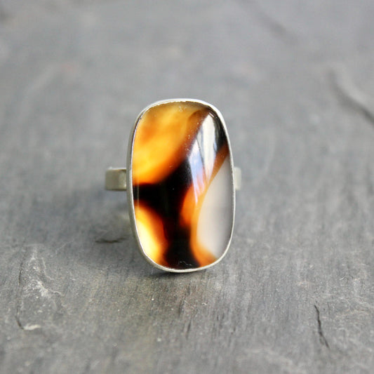 This pretty ring has a large rectangular Montana agate cabochon set in a fine and sterling silver bezel setting on a sturdy hammered band. Handmade by Will Macy in Corvallis, OR.  Size 7