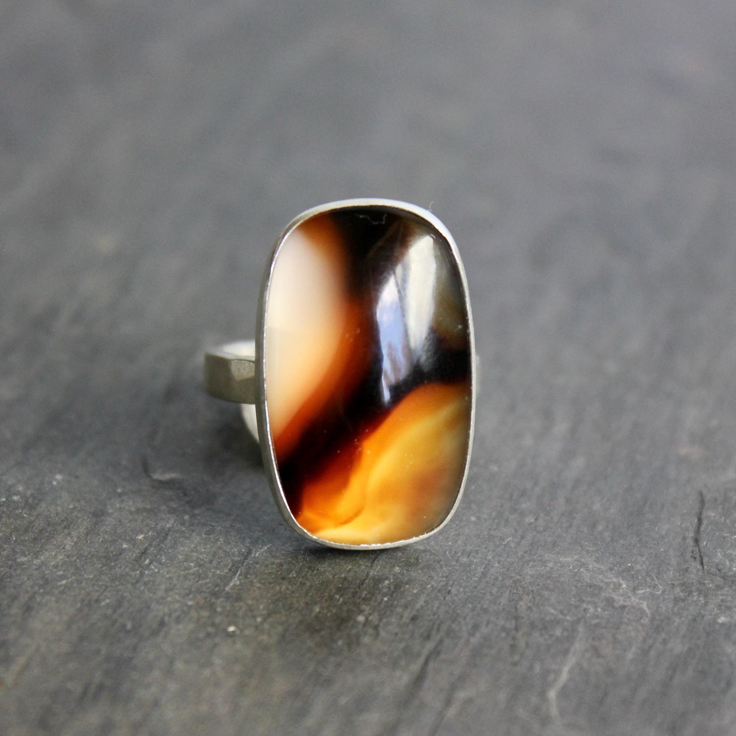 This pretty ring has a large rectangular Montana agate cabochon set in a fine and sterling silver bezel setting on a sturdy hammered band. Handmade by Will Macy in Corvallis, OR.  Size 7