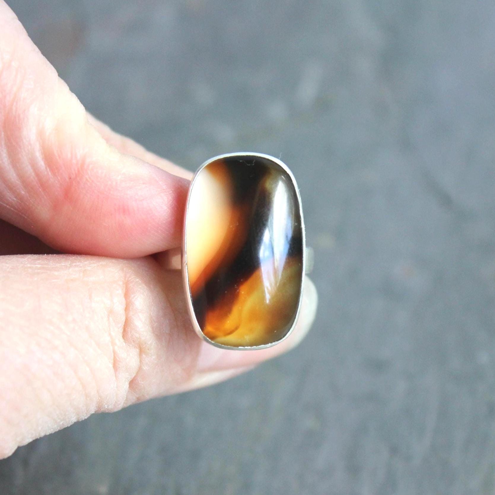 This pretty ring has a large rectangular Montana agate cabochon set in a fine and sterling silver bezel setting on a sturdy hammered band. Handmade by Will Macy in Corvallis, OR.  Size 7