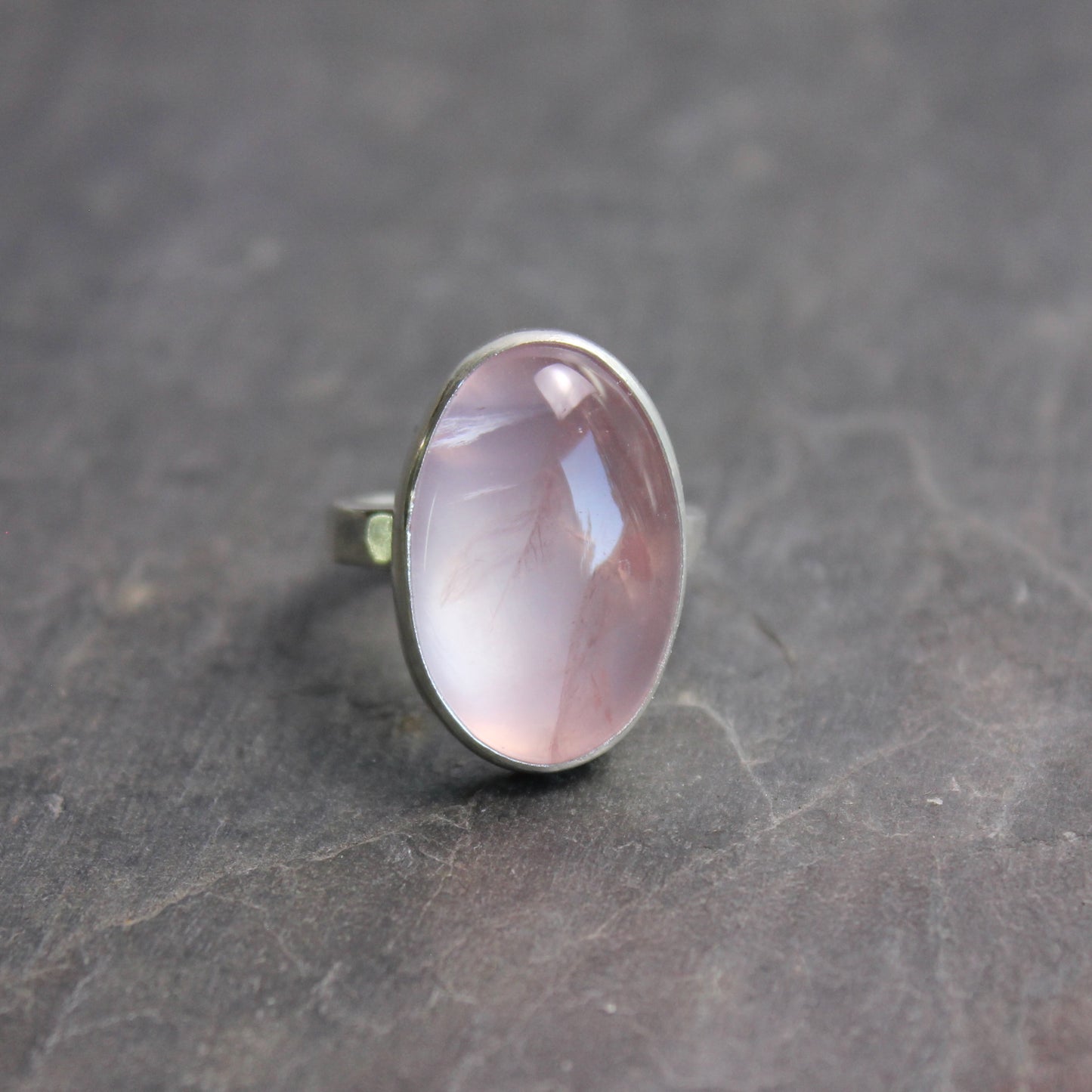 Ring with a rose quartz stone on a dark gray surface