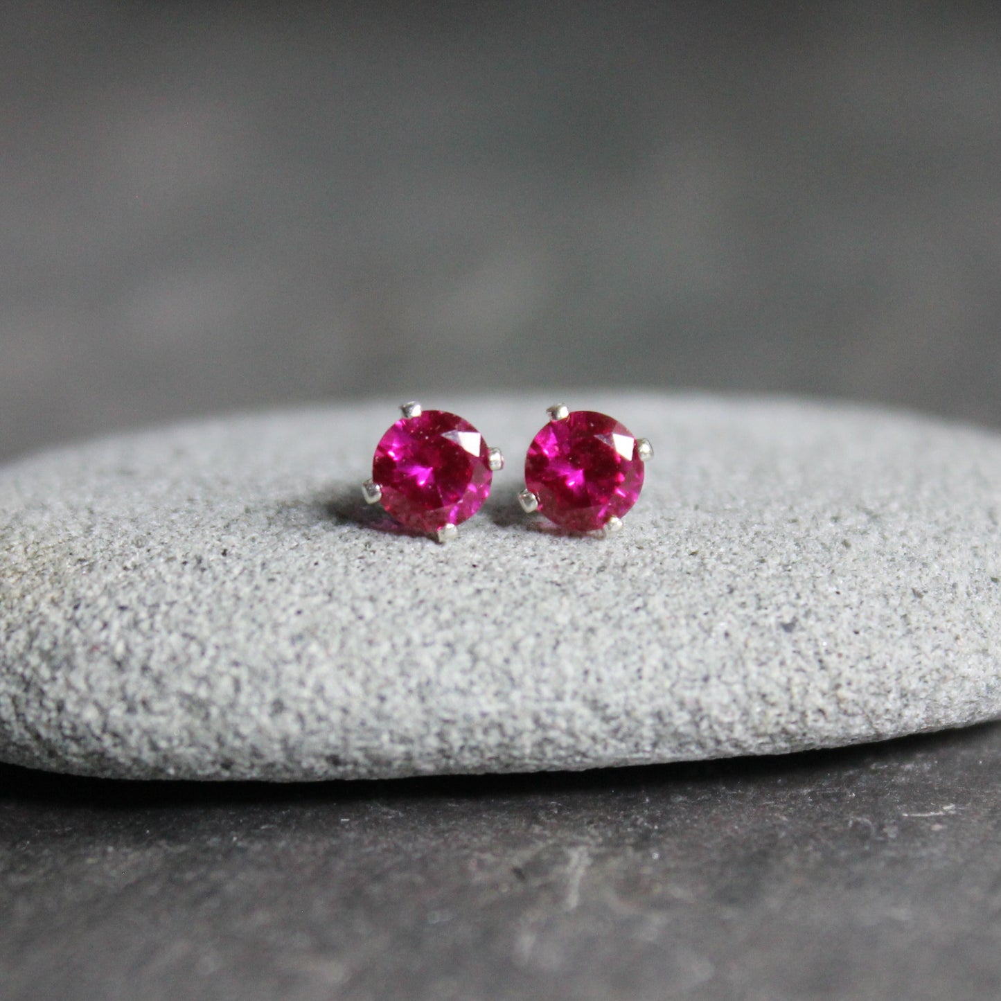 These stud earrings have 4mm round faceted lab created ruby gemstones set in sterling silver 4-prong stud earring settings with earring backs.