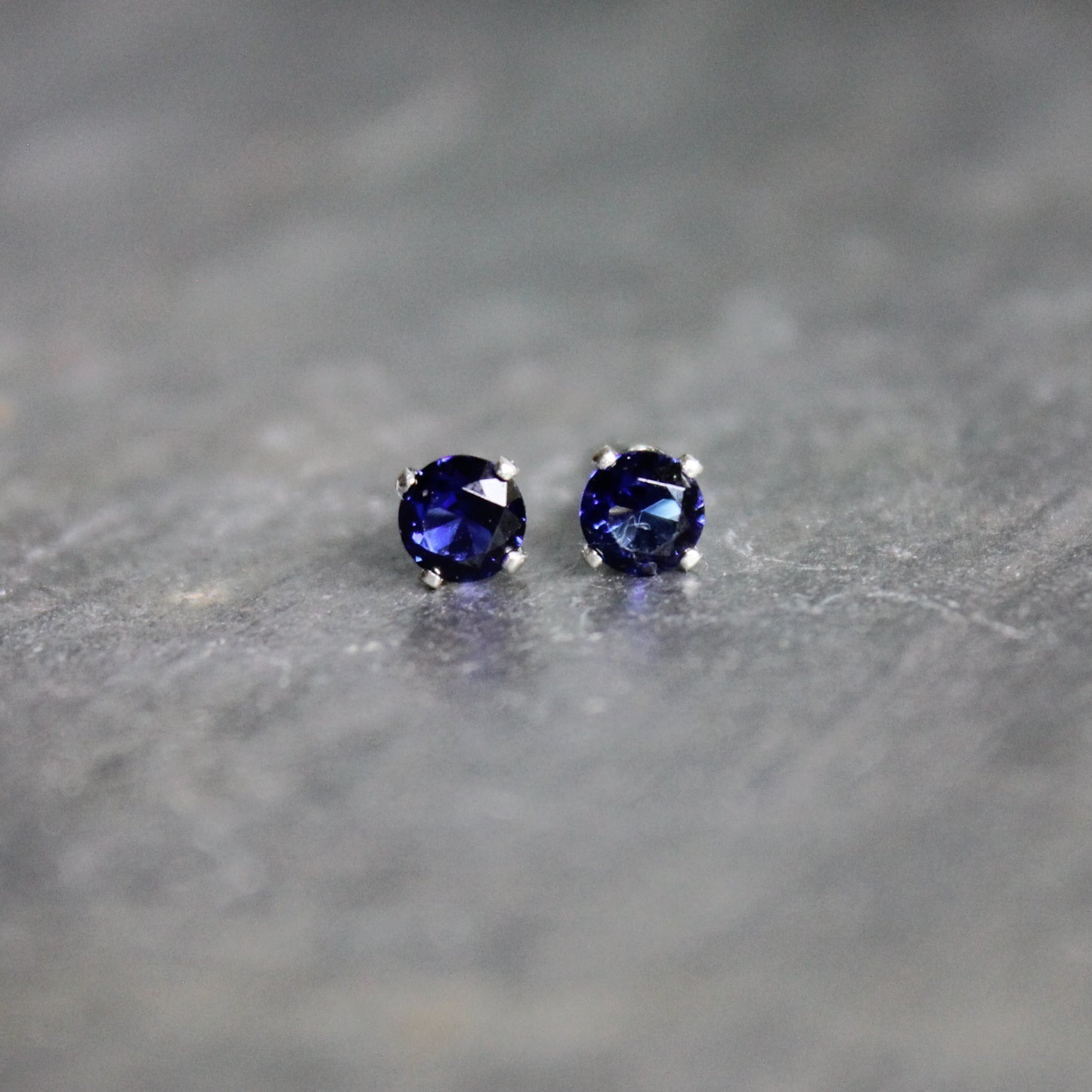 These stud earrings are made with 4mm round faceted lab created sapphires set in 4-prong sterling silver stud earrings with earring backs. 