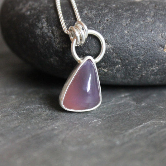 This is a small dark Holley blue agate set in a fine & sterling silver bezel setting and comes with an 18" chain. This stone is triangular shaped