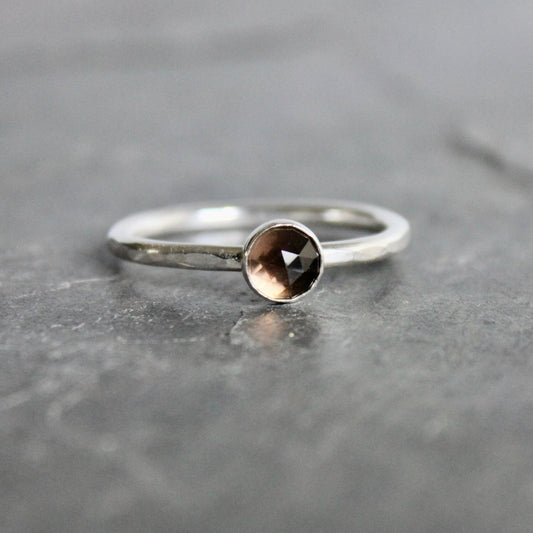 Silver ring with a smoky gemstone on a gray surface