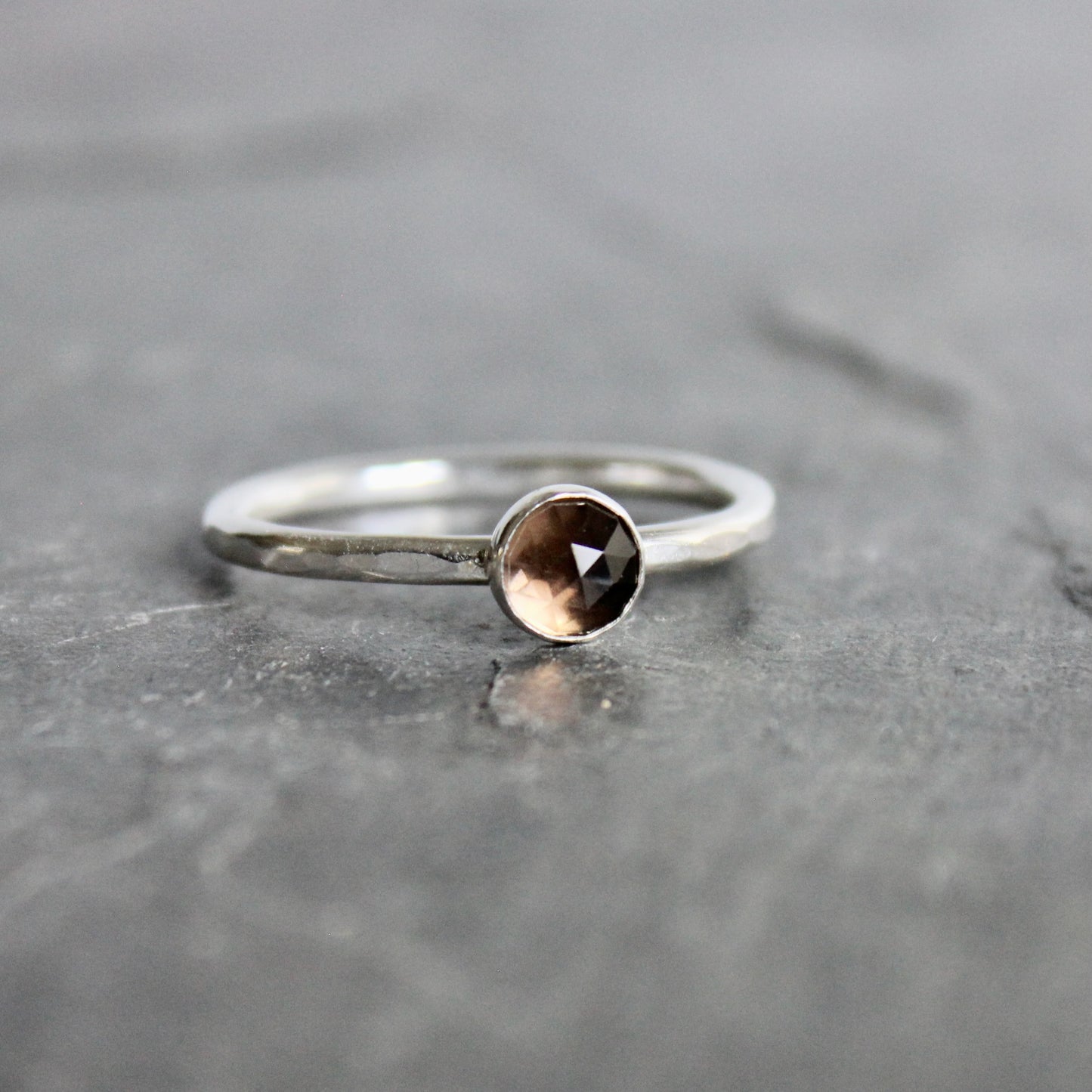 Silver ring with a smoky gemstone on a gray surface