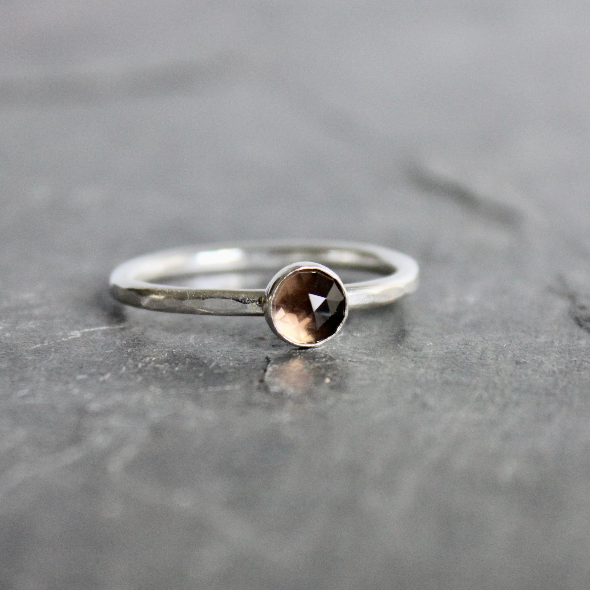 Silver ring with a smoky gemstone on a gray surface