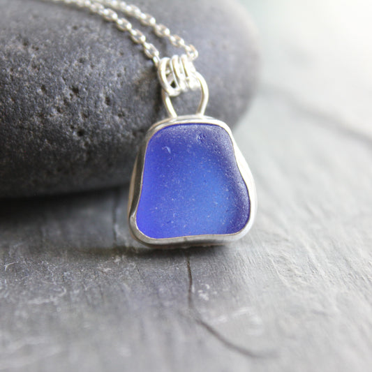 This necklace has a chunky cobalt blue piece of sea glass that is set in a fine and sterling silver bezel setting. 