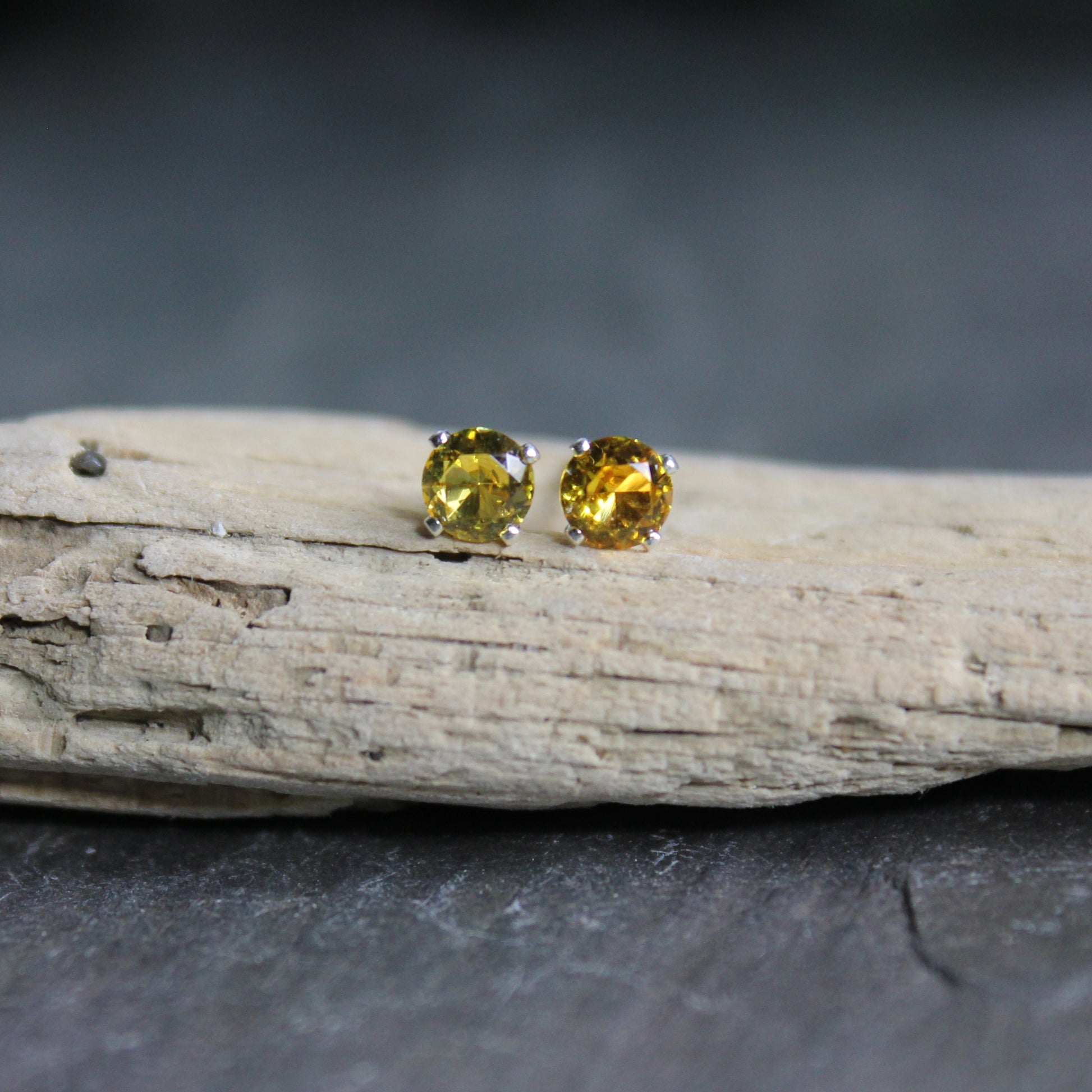 These stud earrings are made with 4mm round faceted lab created golden yellow topaz set in 4-prong sterling silver stud earring settings with earring backs.