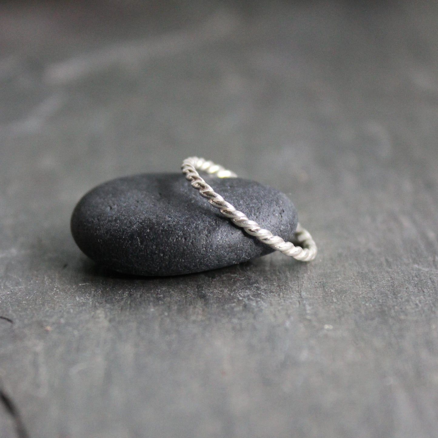 Black stone with a rope on a dark gray surface