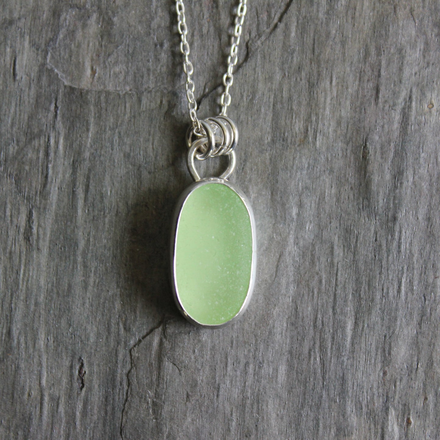 Necklace with a pale-yellow uranium pendant on a gray stone surface