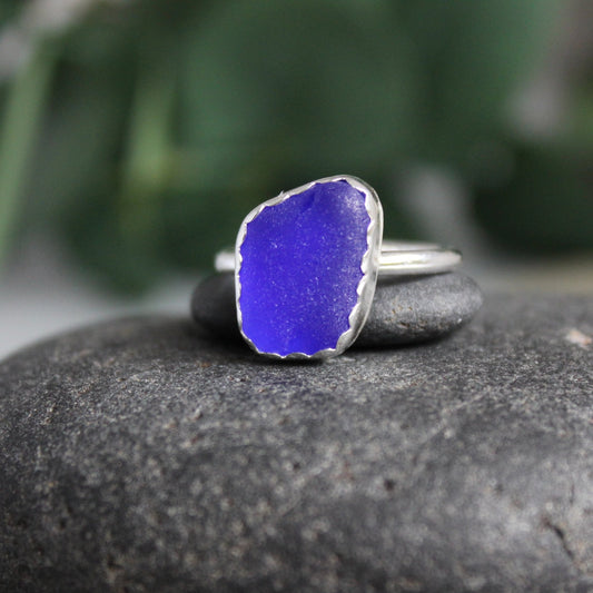 This is a funky shaped piece of cobalt blue sea glass set in a fine and sterling silver scalloped bezel on a sturdy silver band.  Size 7 3/4
